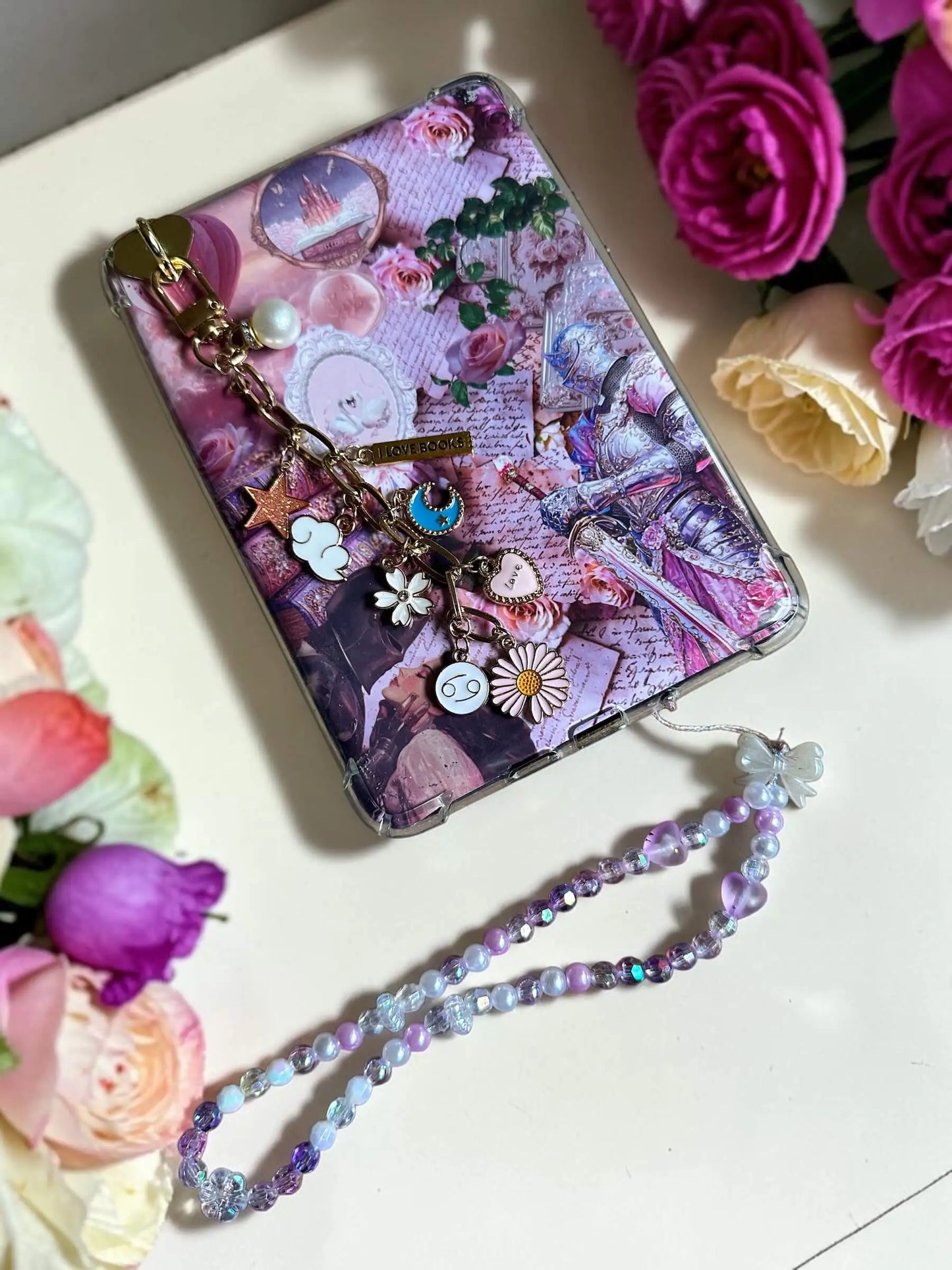 Handmade Lavender Haze beaded Kindle chain attached to a decorative pink bookish Kindle case with roses and fairytale illustrations by Enchanted Bookcase