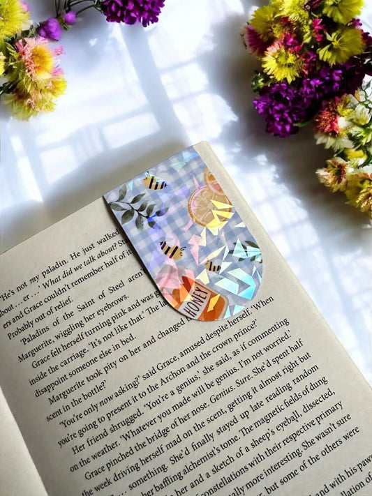 Honey Bee Picnic gingham bees and honey jar holographic magnetic bookmark holding the page in an open book by Enchanted Bookcase