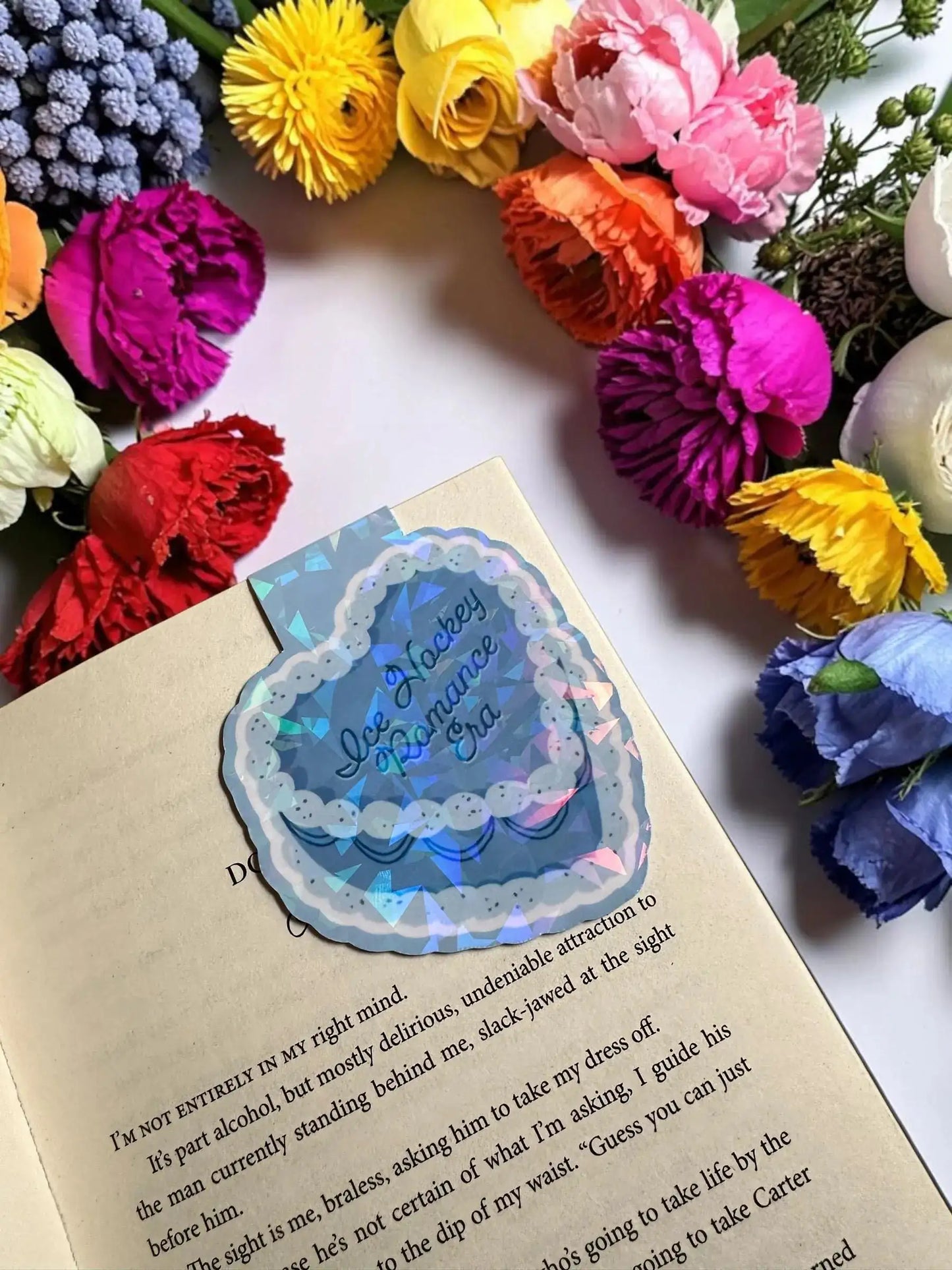 Ice Hockey Romance Era blue scalloped cake holographic magnetic bookmark holding the page in an open book by Enchanted Bookcase