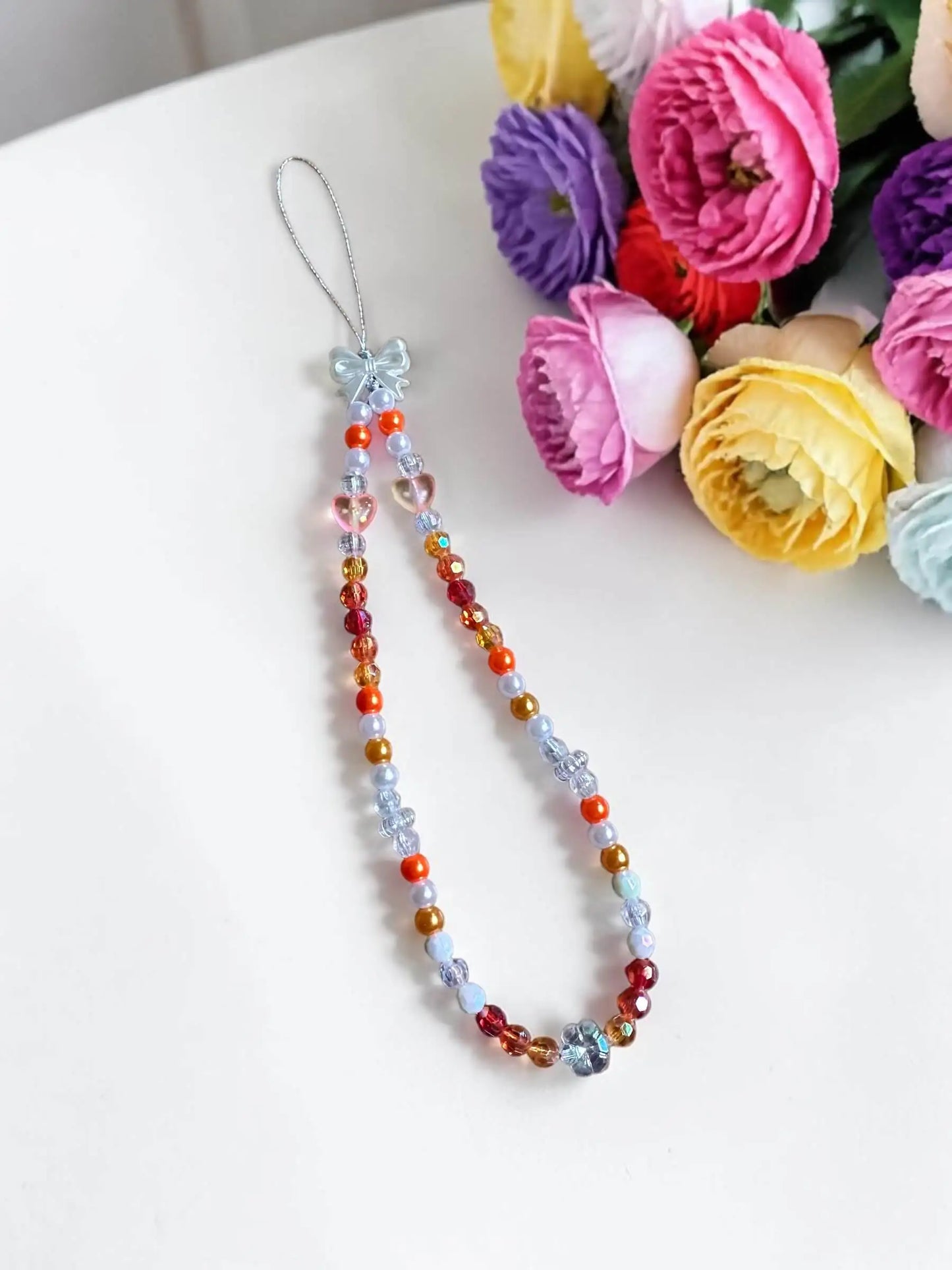 Sunset Glow handmade beaded phone chain with warm orange red and gold beads by Enchanted Bookcase